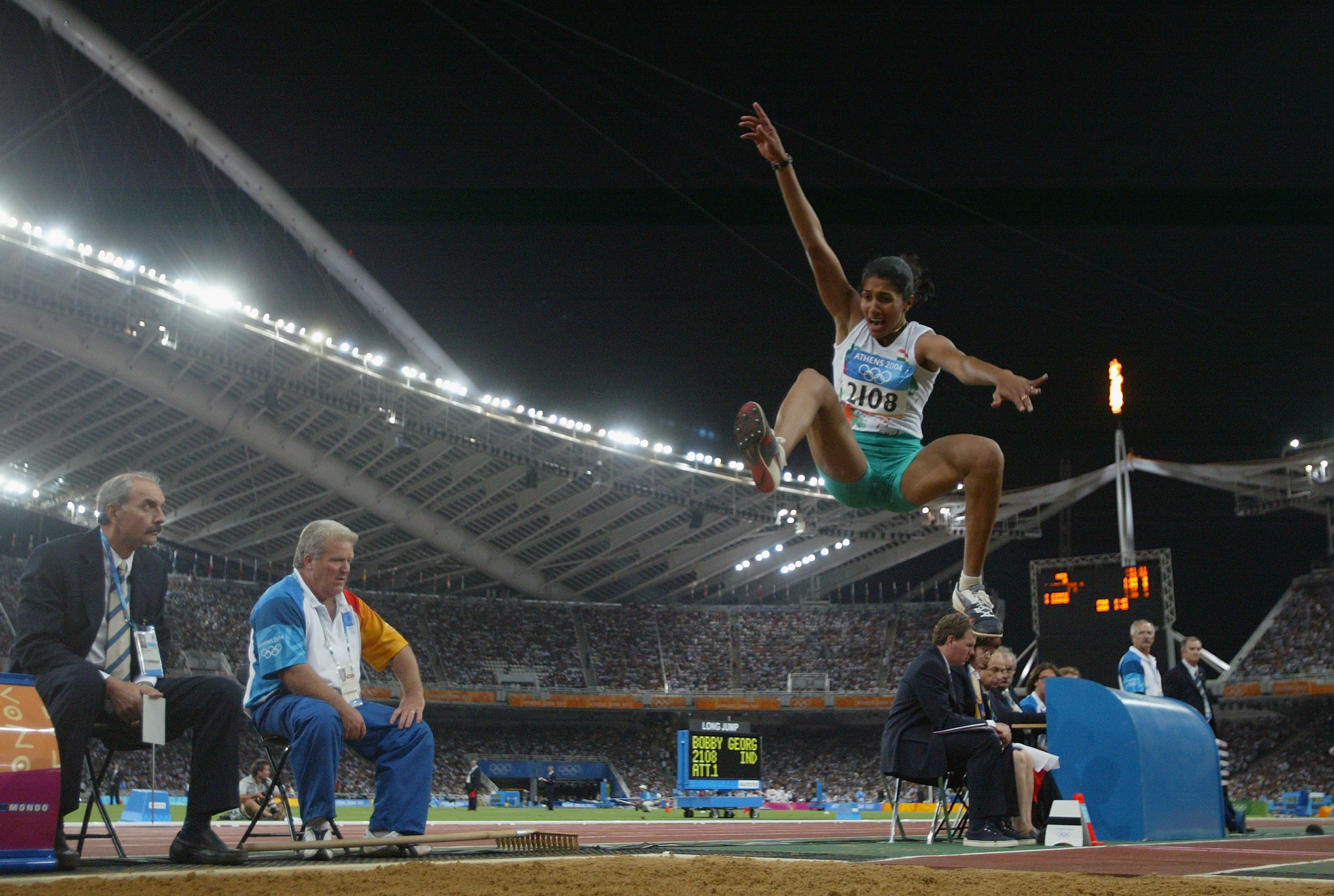 Anju Bobby George competes infront of the Olympic flame in the women's long jump qualifying round on August 25, 2004 during the Athens 2004 Summer Olympic Games